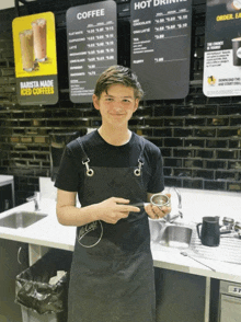 a young man standing in front of a mcdonald 's counter holding a cup