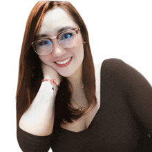 a woman wearing glasses and a black top smiles for the camera