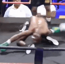 a boxer is laying on the floor in a boxing ring .