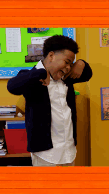 a boy is making a funny face in front of a bulletin board that says " hungry "