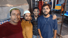 four men posing for a picture with one wearing a shirt that says amb