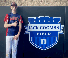 a baseball player is standing in front of a sign for jack coombs field