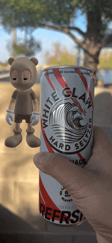 a person is holding a can of white claw hard seltzer in their hand