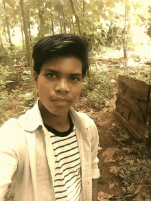 a young man in a striped shirt poses for a picture