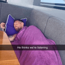 a man is laying on a couch with a purple blanket and a caption that says he thinks we 're listening