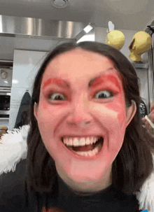 a woman with red paint on her face making a face