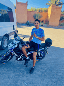 a man sitting on a motorcycle giving a thumbs up sign