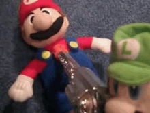 a stuffed mario and luigi toy are holding a gun .