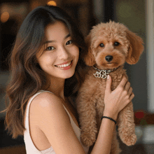 a woman is holding a small brown dog with a collar that says jjss