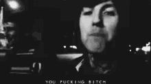 a black and white photo of a man with the words `` you fucking bitch '' written below him .