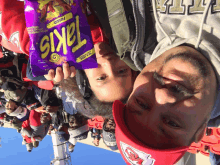 a man and a girl are holding a bag of takis chips