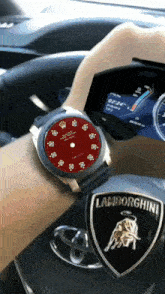 a person wearing a rolex watch is driving a car