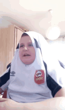 a person wearing a pringles shirt and a hijab on their head