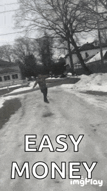 a black and white photo of a person walking down a snowy road with the words easy money behind them