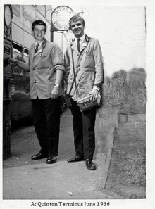 a black and white photo of two men standing next to each other on the sidewalk .