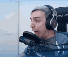 a man wearing headphones is talking into a microphone that says racer on it