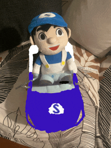 a stuffed toy with the letter s on it is on a bed