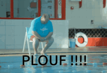 a man sits on a lifeguard chair in front of a swimming pool with the word plouf written on the floor