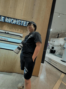 a person standing in front of a store that says e monster