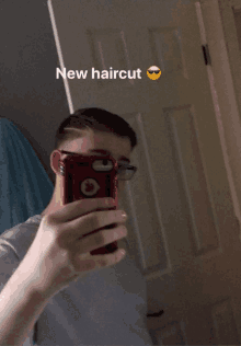 a young man taking a picture of himself with the words new haircut above him