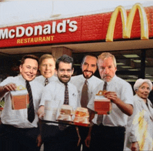 a group of men standing in front of a mcdonalds restaurant