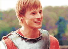 a young man wearing a knight 's armor is smiling