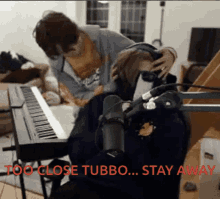 a person playing a piano with the words " too close tubbo ... stay away " in red