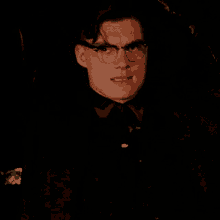 a close up of a man wearing glasses and a black shirt