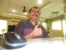 a man giving a thumbs up in front of a mouse