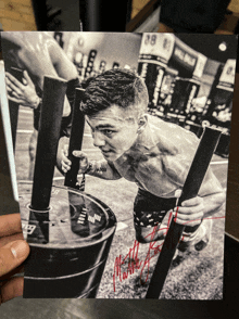 a black and white photo of a man pushing a barrel with the name matthew written on the bottom