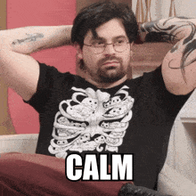 a man wearing a black shirt with a skeleton on it says calm