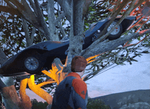 a car that has crashed into a tree with a man standing next to it