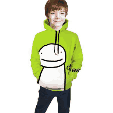 a young boy is wearing a green hoodie with a picture of a dream face on it .