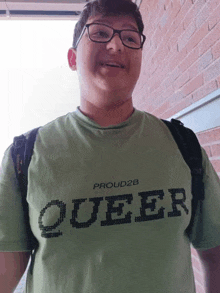 a young man wearing a green shirt that says queer