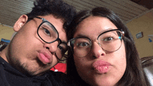 a man and a woman wearing glasses are making a funny face