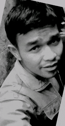 a black and white photo of a young man taking a selfie .