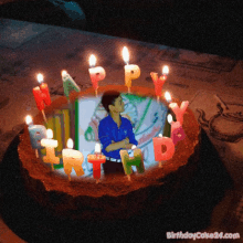 a picture of a man on a birthday cake with candles that say happy birthday