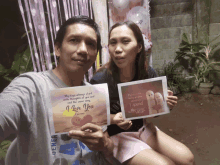 a man and a woman holding a card that says " i love you "