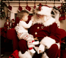 a little boy sitting on santa 's lap pointing to something