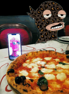 a pizza on a table with a phone that says gucci on the screen