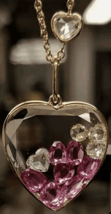 a heart shaped pendant filled with pink stones and diamonds