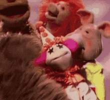 a group of stuffed animals are standing next to each other and one of them is wearing a clown costume .