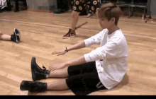 a person is sitting on the floor stretching their legs