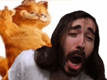 a man with long hair and a beard is yawning next to a garfield cat .