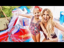 a woman and a little girl in swimsuits are playing in a pool .