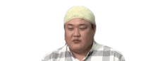 a fat man wearing a towel on his head is making a funny face .