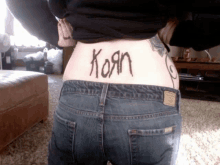 a person with a tattoo on their back that says korn