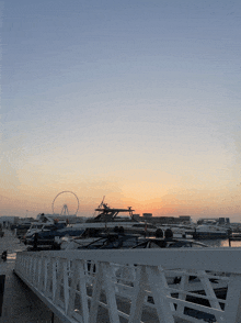 a ferris wheel is visible in the distance behind a marina