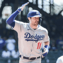 a dodgers baseball player wearing number 11 runs towards the dugout