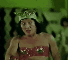 a man wearing a crown and a red bra is standing in a room .